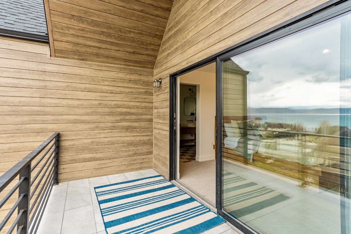 Master Bedroom Balcony with Large Sliding Doors and Black Railing in Bear Lake Custom Home by 10X Builders